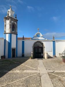 ペニシェにあるCASAS das ESTRELAS PENICHE sur la presqu île Hebergements tout confort Proche centre villeの時計塔のある白青の建物