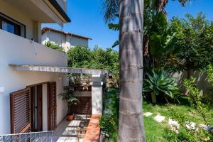 a palm tree in front of a house at Loft Pina in Àrbatax