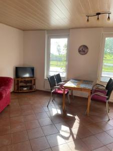 a living room with a table and chairs and a tv at Haus Denker in Brunsbüttel +23 photos