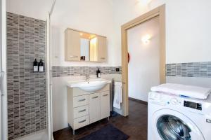 a bathroom with a sink and a washing machine at La Maison De Carletto in Sarre