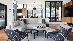 ein Wohnzimmer mit einer Couch und einem Tisch und Stühlen in der Unterkunft Coomalie in Palm Beach