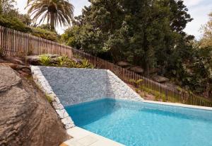 ein Pool in einem Garten mit einem Zaun in der Unterkunft Coomalie in Palm Beach