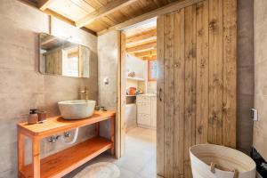 La salle de bains est pourvue d'un lavabo et d'un mur en bois. dans l'établissement Rodies House, à Fánai 15 autres photos