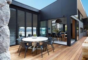 ein Esszimmer mit einem weißen Tisch und Stühlen auf einer Terrasse in der Unterkunft Coomalie in Palm Beach