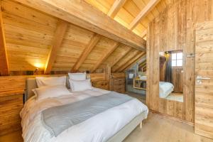 a bedroom with a bed in a log cabin at Magnifique Appartement Le Taillefer in Villard-Reculas