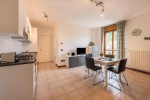 トスコラーノ・マデルノにあるVilla Bornico Marisaのテーブルと椅子のあるキッチンとリビングルーム