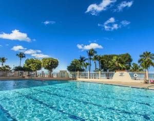 a large swimming pool at a resort with palm trees at Stylish Designed 1BR Coral Beach by Stay Here PR in San Juan