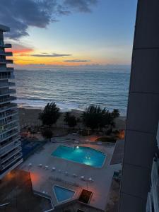 a view of the ocean at sunset from a building at Stylish Designed 1BR Coral Beach by Stay Here PR in San Juan