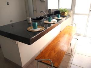 a kitchen counter with three plates and a sink at O Connor Santiago del Estero in Santiago del Estero