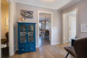 a blue cabinet in a living room with a dining room at Wohnen am See bei Heike und Jens in Zwenkau +2 photos