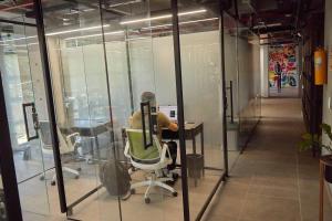 una persona sentada en un escritorio en una oficina en Factory Lofts Hotel, en Medellín