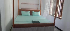 a bedroom with a bed with blue sheets and a window at Samaya guesthouse in Tangalle