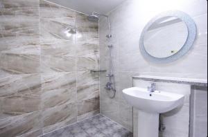 une salle de bain avec un lavabo et un miroir dans l'établissement Andong W Motel, à Andong