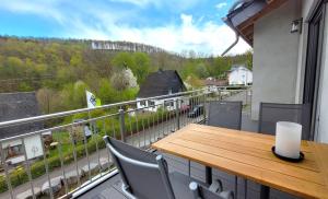a balcony with a wooden table and chairs at Gittas Paradiesperle in Niederdreisbach