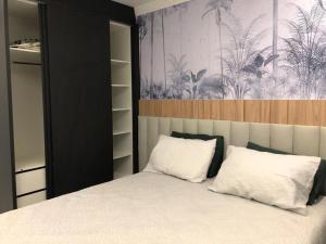 Un dormitorio con una cama con almohadas blancas. en Safira, en Meia Praia