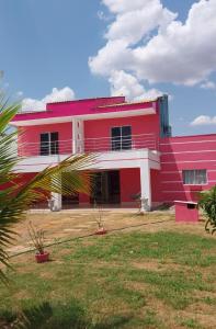 - un bâtiment rouge et blanc avec une grande cour dans l'établissement Casa Sobrado Confortavel, Descanso Garantido, à Cuiabá