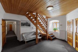 a living room with a wooden staircase and a couch at Hotel BELLA in Prague +19 photos