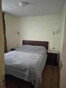 een slaapkamer met een bed en twee lampen aan de muur bij Aires in La Serena