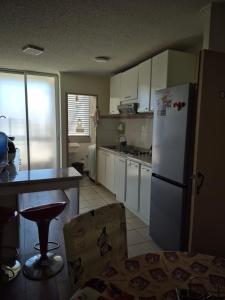 een keuken met een witte koelkast en een tafel bij Aires in La Serena +2 foto's