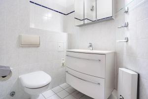 a white bathroom with a toilet and a sink at Typ 3 Ferienwohnung 22 in Ostseebad Sellin +21 photos