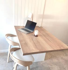 a laptop computer sitting on top of a wooden table at WaVes - couples retreat near the ocean in Kinross