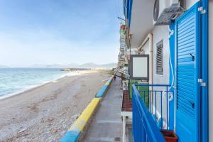 a building next to the beach with blue doors at Casa Henriette in Palermo