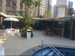 a hot tub in the middle of a patio with tables and trees at Apartamento 3 quarto com ótima área de lazer in Caldas Novas