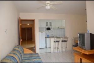 a living room with a couch and a kitchen at Apartamento 3 quarto com ótima área de lazer in Caldas Novas
