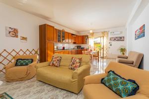 a living room with two couches and a kitchen at Il Giardino Delle Ninfe Sea in Mascali