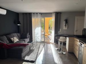 een woonkamer met een bank en een keuken bij Love Room L Interlude in Vitrolles