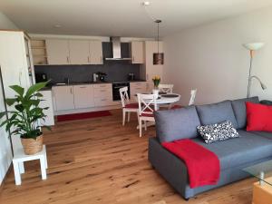 a living room with a blue couch and a kitchen at Ferienwohnung Im Eyachtal in Albstadt