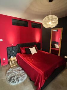 een rode slaapkamer met een bed met een rode muur bij Love Room L Interlude in Vitrolles