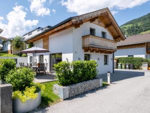 a white house with a wooden roof at Cervus in Bruck an der Großglocknerstraße
