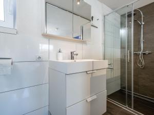 a white bathroom with a sink and a shower at Cervus in Bruck an der Großglocknerstraße +23 photos