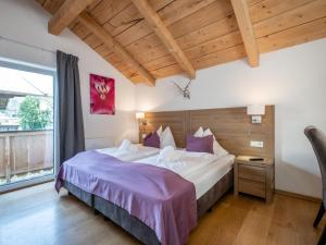 a bedroom with a large bed with purple sheets at Cervus in Bruck an der Großglocknerstraße