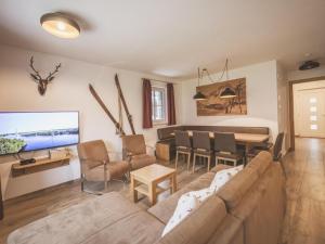 a living room with a couch and a dining room at Lodge Amanda in Wald im Pinzgau