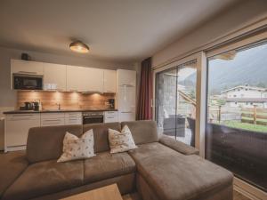 a living room with a couch and a kitchen at Lodge Amanda in Wald im Pinzgau