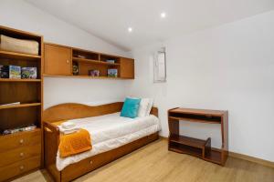 a small bedroom with a bed and a desk at Moradia dos Castelos Amarelo in Santarém +27 photos