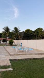 two tables and chairs sitting in a park at Casa para temporada pertinho do mar in São José de Ribamar