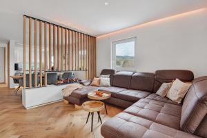 a living room with a couch and a fireplace at Bayerwald Refugium in Schwarzach