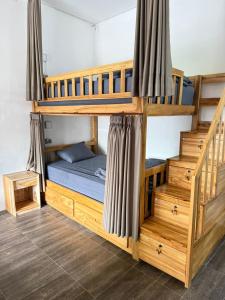 a bedroom with two bunk beds with a blue bed at AMED LILI Hostel & Private Room in Amed