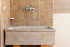 un lavabo en pierre dans une douche avec un robinet dans l'établissement Corte Nonna Mmela, à Melendugno 14 autres photos