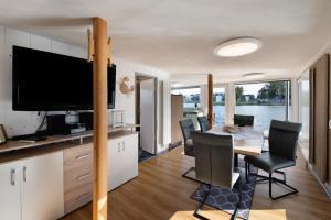 a kitchen and dining room with a table and a television at Bootshaus Fritze Bollmann in Waren