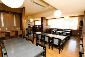 a dining room with tables and chairs and lights at ホテルララプラス in Nirasaki