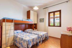 two beds in a room with a bunk bed at Sa Domu de Ettore in Santa Maria Navarrese