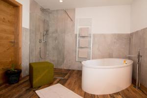 ein Badezimmer mit einer großen Badewanne und einer Dusche in der Unterkunft Haus Arnold - Privatzimmer und Ferienwohnungen in Sillian