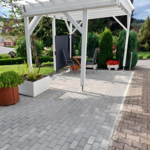 a white pergola with a table and chairs on a patio at Ferienwohnung Klink in Waldachtal