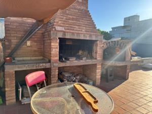 a brick oven with a table and a table and a chair at Plaza Godoy Cruz, habitacion y baño privado en casa 6 ambientes terraza parrilla in Godoy Cruz