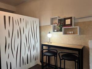 a bar with two chairs and a table with a lamp at Plaza Godoy Cruz, habitacion y baño privado en casa 6 ambientes terraza parrilla in Godoy Cruz +15 photos