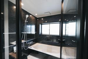 ein Badezimmer mit Badewanne und Fenster in der Unterkunft ゆたか in Kajiya + 63 Fotos